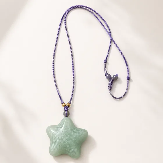 A carved jade star with grey moonstone and gold beads.