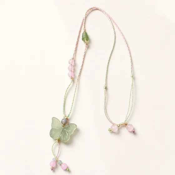 A carved jade butterfly with rose quartz, aquamarine, a small jade gourd and gold beads.